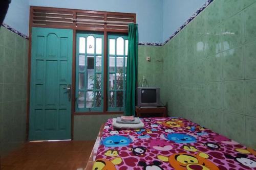 1 dormitorio con 1 cama y TV. en OYO 93394 Pondok Wisata Kurniawan 2, en Yogyakarta