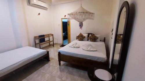 a bedroom with two beds and a mirror at Jaana Guest in Sigiriya