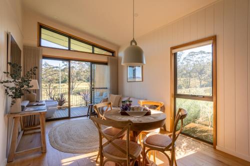 a dining room and living room with a table and chairs at Cupitt's Estate Villas in Ulladulla