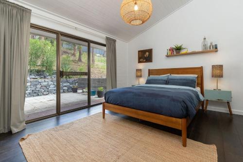 1 dormitorio con cama y ventana grande en Nordhaus, en Smiths Lake
