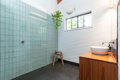 baño con bañera, lavabo y ventana en Nordhaus, en Smiths Lake