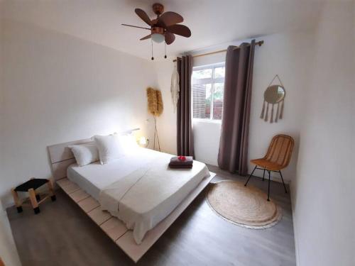 - une chambre avec un lit et un ventilateur de plafond dans l'établissement Charmante villa de vacances à Moorea, à Afareaitu
