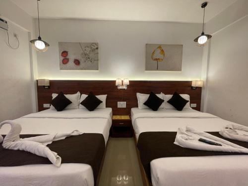 een hotelkamer met drie bedden en drie verlichting bij Yellow Sky in Baga
