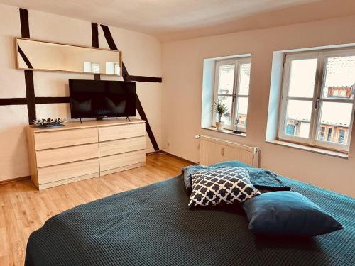 a bedroom with a bed and a television on a dresser at Studio Reichenstrasse in Quedlinburg