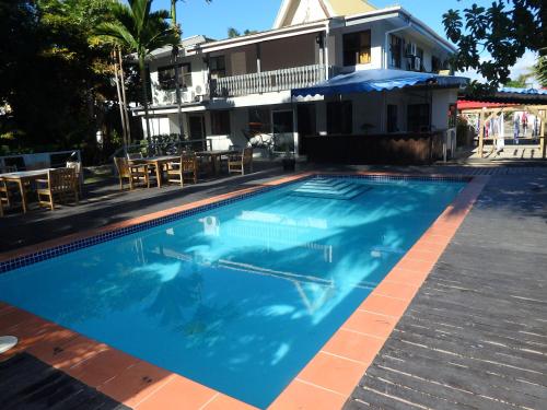 a swimming pool in front of a house at Bluewater Lodge in Nadi