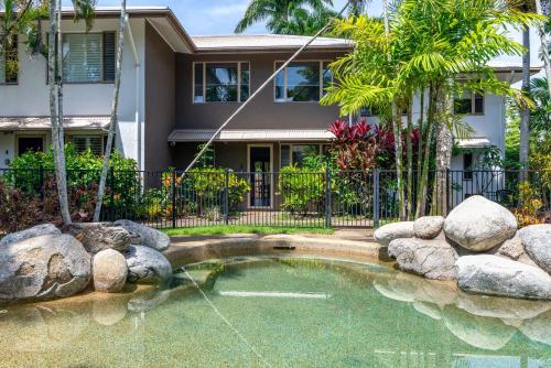 a house with a pond in front of a house at 5 Reef Terraces in Port Douglas