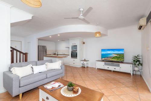 a living room with a couch and a table at 5 Reef Terraces in Port Douglas