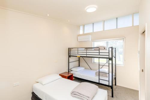 Un dormitorio con dos literas y una ventana. en NRMA Eastern Beach Holiday Park, en Lakes Entrance