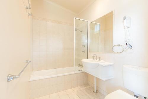 a bathroom with a shower toilet and a sink at NRMA Eastern Beach Holiday Park in Lakes Entrance