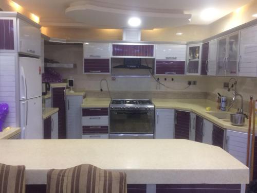 una grande cucina con armadi bianchi e piano di lavoro di شاليه الراحة a Al Majmaah