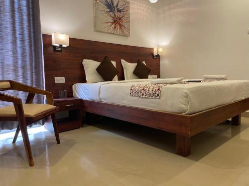 a bedroom with a large bed and a chair at Yellow Sky in Baga