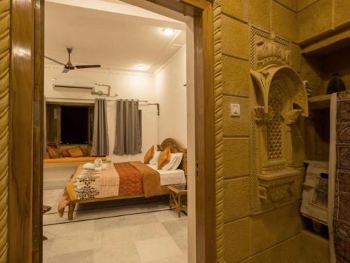 um quarto com uma cama e um quarto com uma janela em Ideal Guest House em Jaisalmer