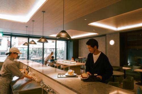 two people standing at a counter in a restaurant at FAV LUX Nagasaki in Nagasaki