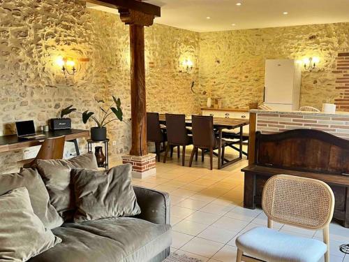 ein Wohnzimmer mit einem Sofa und einem Tisch in der Unterkunft Petit coin de paradis Albigeois in Castelnau-de-Lévis