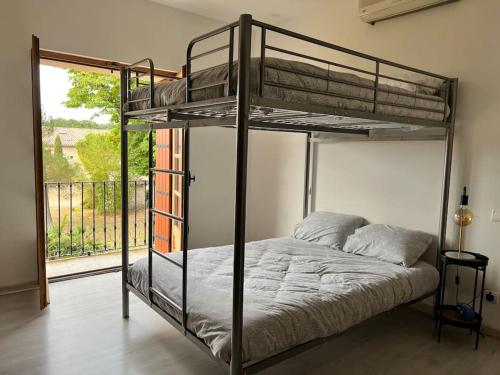 Schlafzimmer mit Etagenbett und Balkon in der Unterkunft Petit coin de paradis Albigeois in Castelnau-de-Lévis