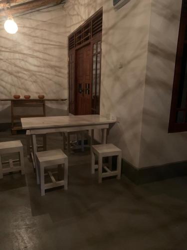 a room with a table and two stools and a bench at SONYA GARDEN View in Weligama