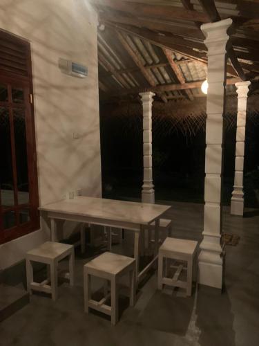 a picnic table and two stools in a room at SONYA GARDEN View in Weligama