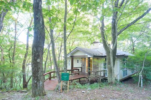 a small house with a deck in the woods at Suite Villa Nasukogen Terrace in Nasu