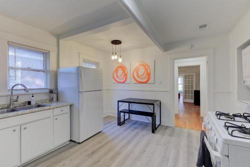 a kitchen with white appliances and a black table at Charming Cooper-Young Flat in the Heart of Memphis in Memphis