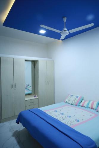 a bedroom with a bed with a blue ceiling at HOMESTAY ( EAGLE NEST ) in Bhuj