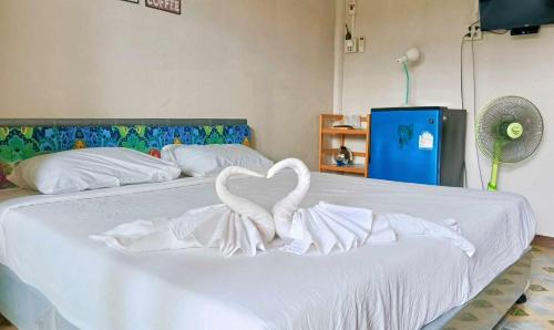 Una cama blanca con dos cisnes formando un corazón en LUCKY Bungalows Koh Mook en Ko Mook