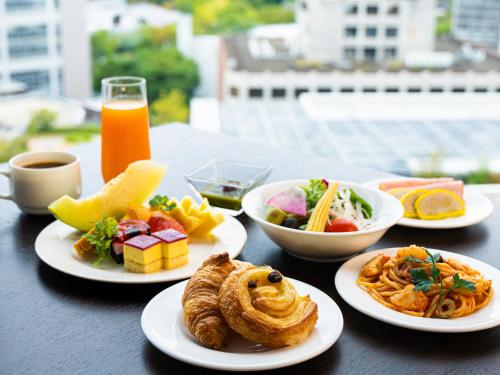 a table with plates of food on a table at KOKO HOTEL Premier Kumamoto in Kumamoto