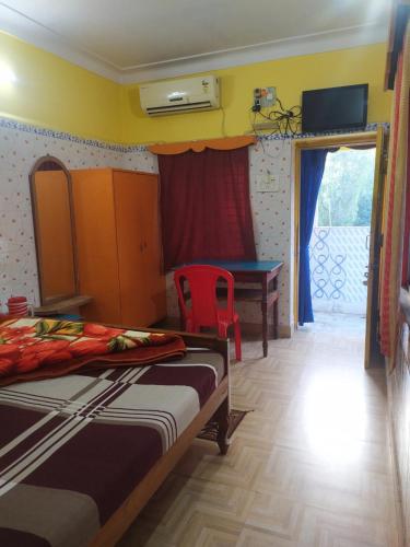 a bedroom with two beds and a table and a desk at PAYEL LODGE in Digha