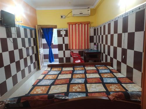 a bedroom with a bed with a checkerboard wall at PAYEL LODGE in Digha