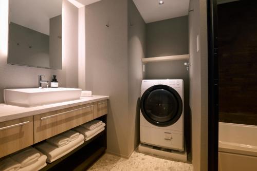 a bathroom with a sink and a washing machine in it at FAV LUX Nagasaki in Nagasaki