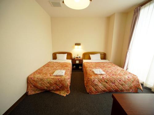 una camera d'albergo con due letti e un tavolo di HOTEL MARINEPIA - Vacation STAY 92240v a Shinkamigoto