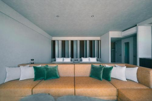 a room with a couch with green and white pillows at FAV LUX Nagasaki in Nagasaki