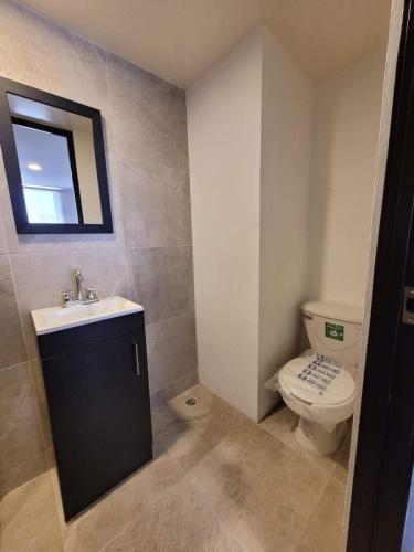 a bathroom with a toilet and a sink and a mirror at Departamento Amueblado in Puebla