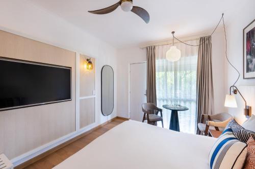 a hotel room with a bed and a flat screen tv at Mantra Club Croc in Airlie Beach