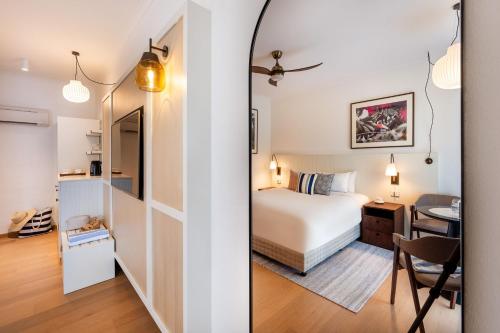 a bedroom with a bed and a desk with a chair at Mantra Club Croc in Airlie Beach
