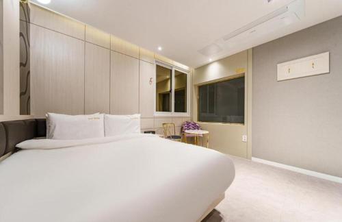 a bedroom with a large white bed in a room at Hotel Bon in Tongyeong