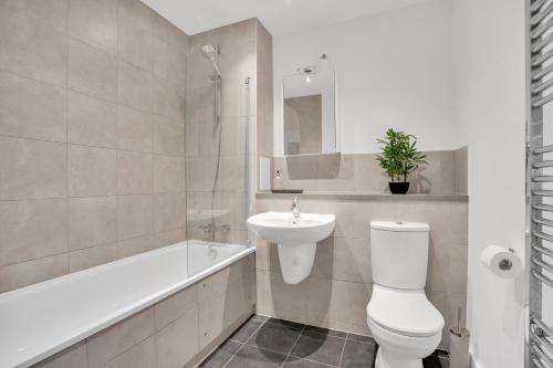uma casa de banho com um WC, um lavatório e uma banheira em Spacious 2 bedroom apartment with balcony em Londres