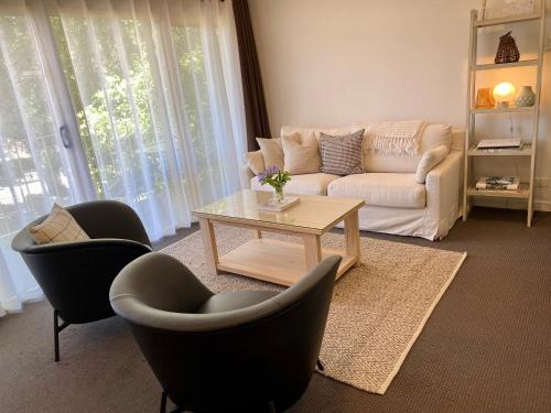 a living room with a couch and chairs and a table at Angaston Mews Apartments in Angaston