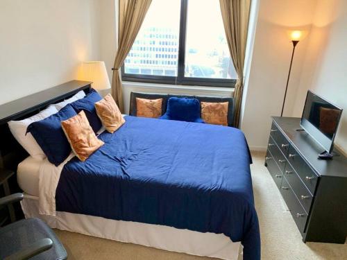 a bedroom with a large blue bed with a window at Executive Suite at Crystal City - 1BR, Metro, Gym, Free Parking in Arlington