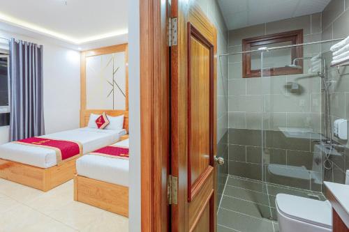 uma casa de banho com uma cama, um chuveiro e um WC. em Ngọc Sang 1 Hotel em Da Lat