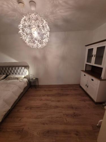 a bedroom with a bed and a chandelier at JAMYS Wohnung in Bremen