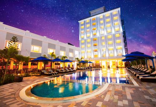 a hotel with a swimming pool in front of a building at Ocean Pearl Hotel Phu Quoc in Phu Quoc