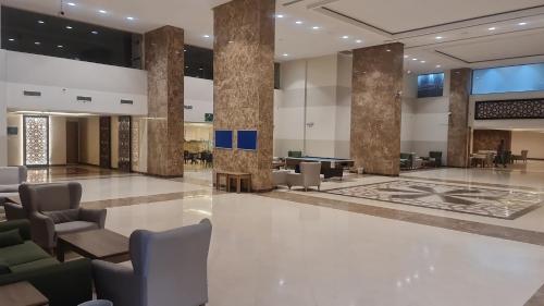 een lobby met stoelen en tafels in een gebouw bij شقق فندقية التلال in Mekka