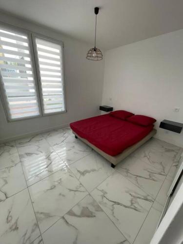 um quarto com uma cama vermelha num quarto branco em Appartement 2 pieces, salon et chambre, 44m2 refait à neuf em Clichy