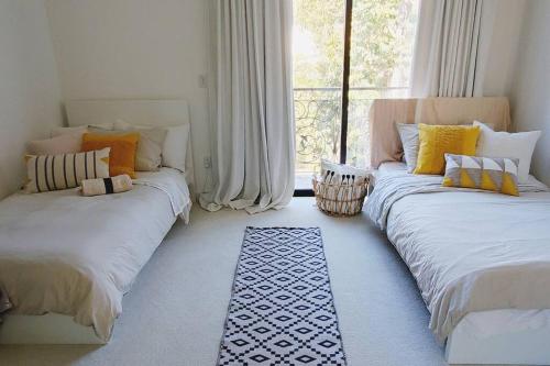 2 camas en una habitación con ventana en Stylish Pacific Palisades Gem, en Los Ángeles