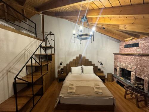 a bedroom with a bed in a room with a fireplace at Hotel Ambassador Voskopojë in Voskopojë