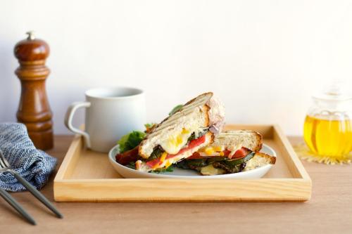 ein Sandwich auf einem Teller auf einem Holztablett in der Unterkunft THE MACHIYA HOTEL TAKAYAMA in Takayama