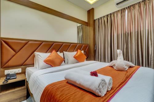 a bedroom with a bed with a stuffed animal on it at Hotel Archith in Navi Mumbai