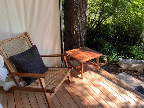 a wooden deck with a table and a chair at Lopez Farm Cottages & Tent Camping in Lopez