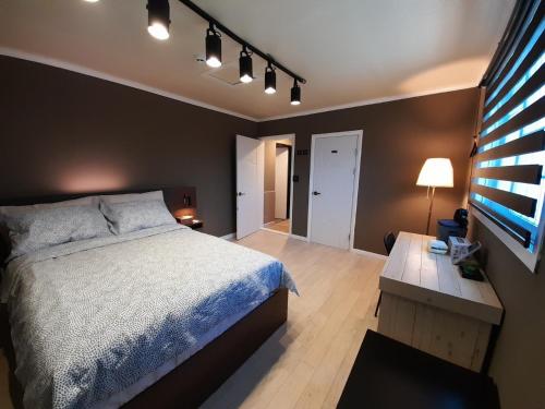 a bedroom with a bed and a table and a television at Cheongju Soo stay in Cheongju