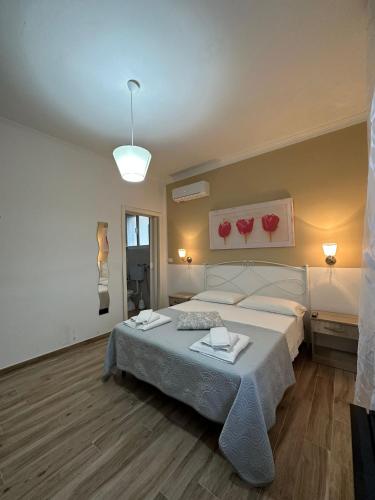 a bedroom with a bed with two towels on it at Giardino dei Baroni house in Marina di Mancaversa